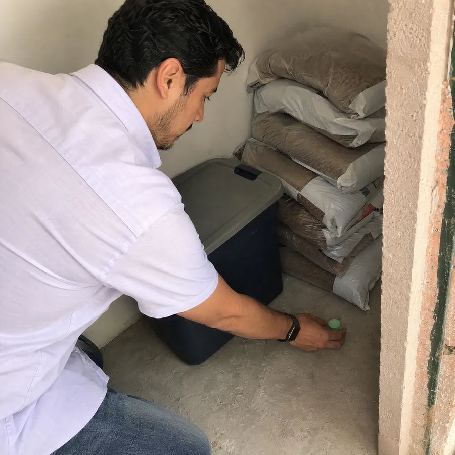 Emmanuel coloca una pastilla Rinco en la esquina de la bodega de su patio, junto a unos costales