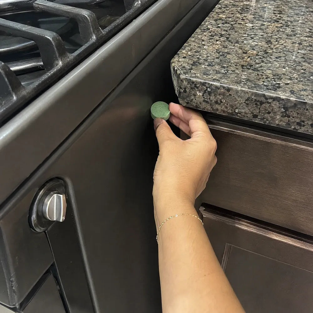 Itzel pone una pastilla verde Rinco en el hueco entre la estufa y el mueble de su cocina